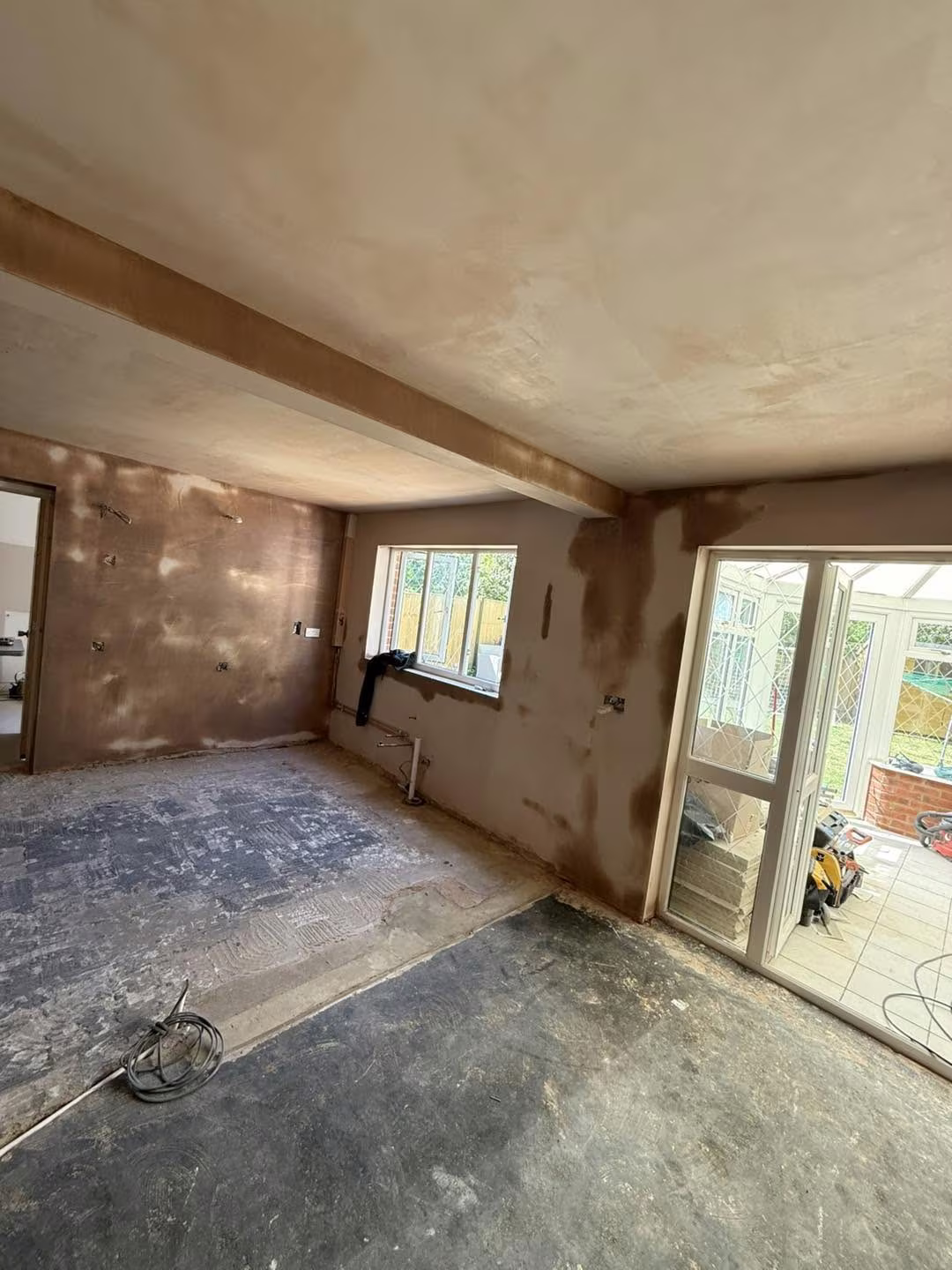 A through-lounge freshly skimmed, with a boxed beam across the ceiling and doors out to a conservatory